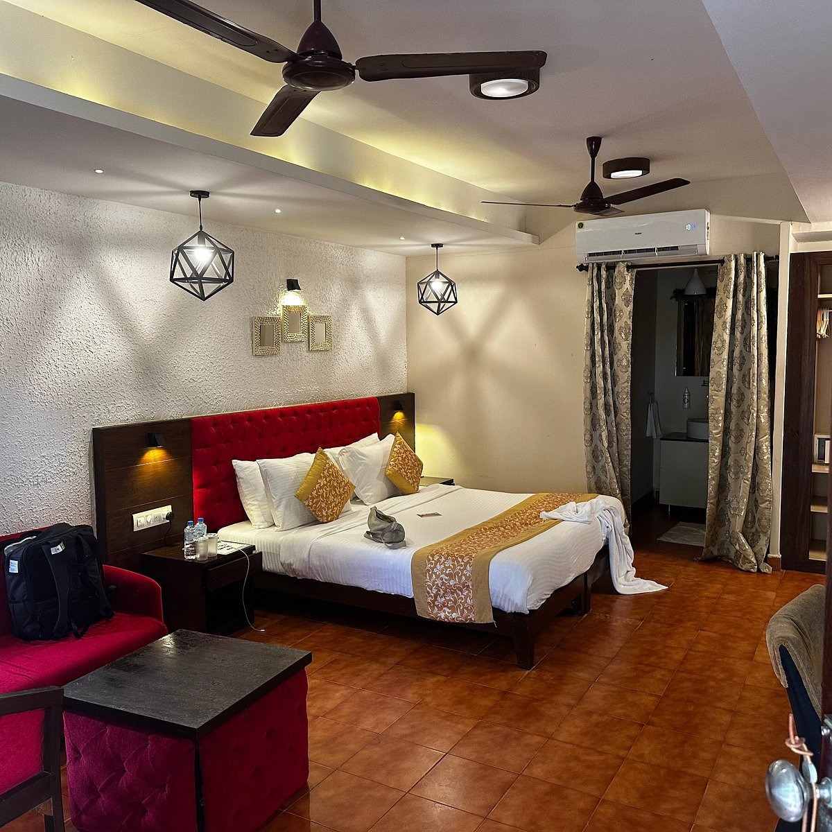 Premium Velvet Suite with red velvet headboard and chandeliers
